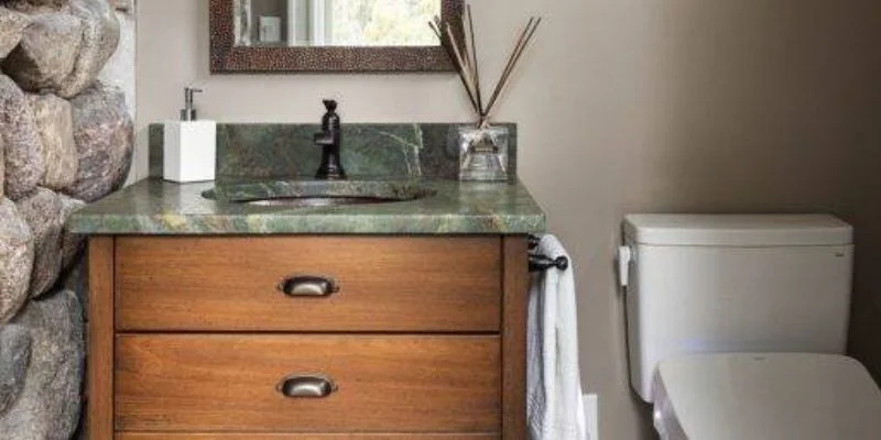 a small bathroom with gray walls and wood accents 